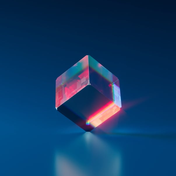 a glass cube on a reflective background, refracting red color